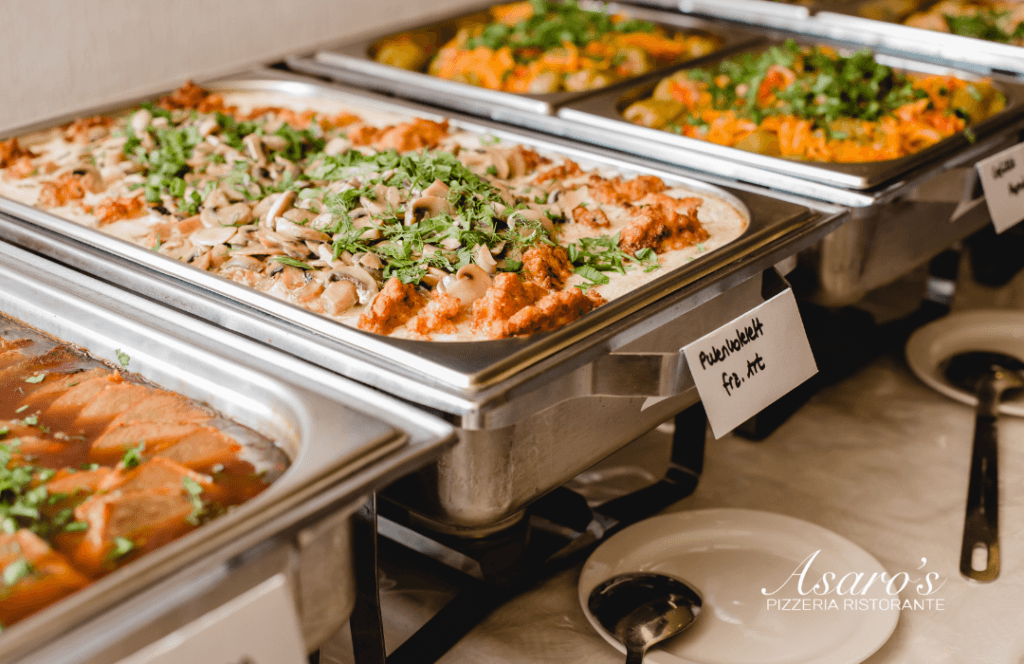 Italian catering spread in chafing dishes with chicken, mushroom pasta, and stuffed peppers prepared by Asaro's Pizzeria Ristorante for a Sarasota event